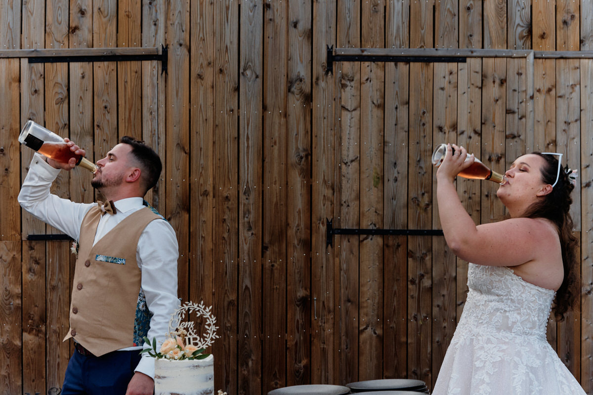 Couple de mariés buvant du champagne à même la bouteille