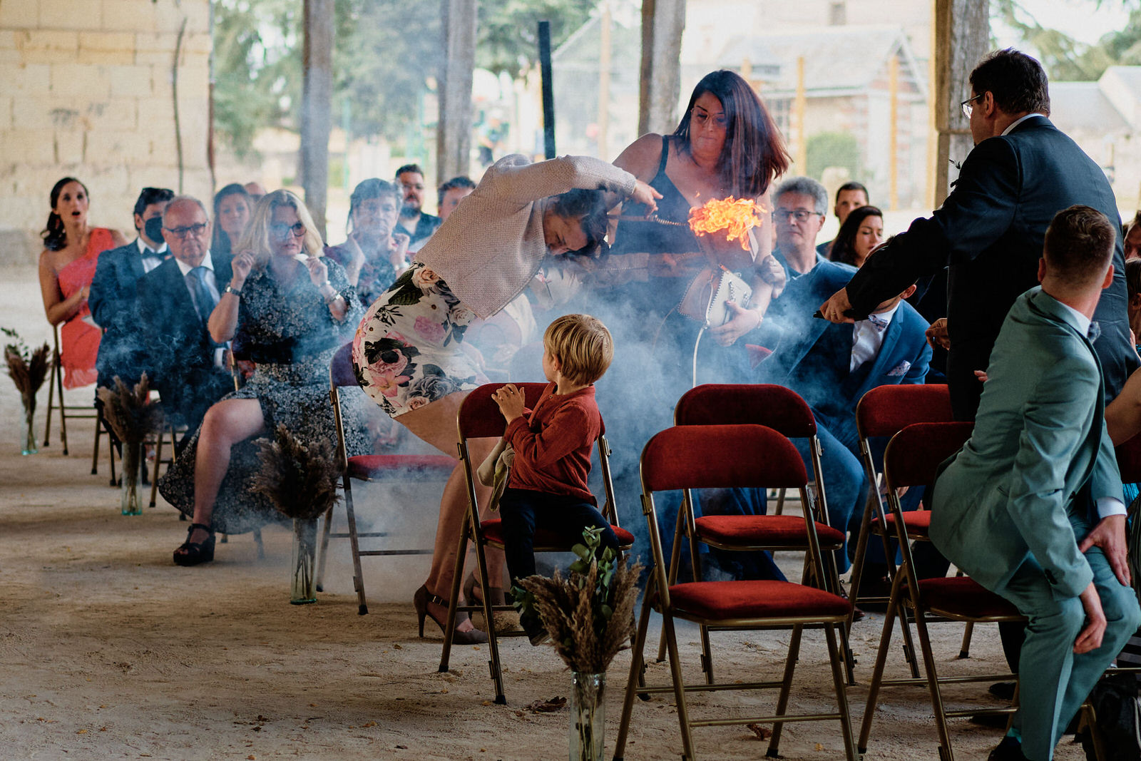 Une invitée de mariage lance son sac en flammes loin d'elle pendant une cérémonie