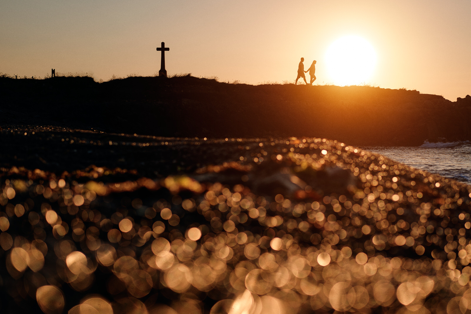 couple qui marche au loin en silhouette au coucher de soleil