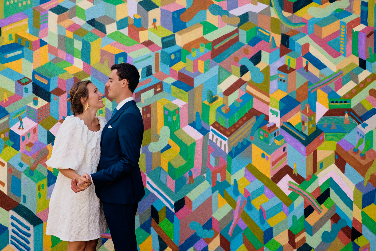 Couple posant devant un mur coloré pendant un mariage