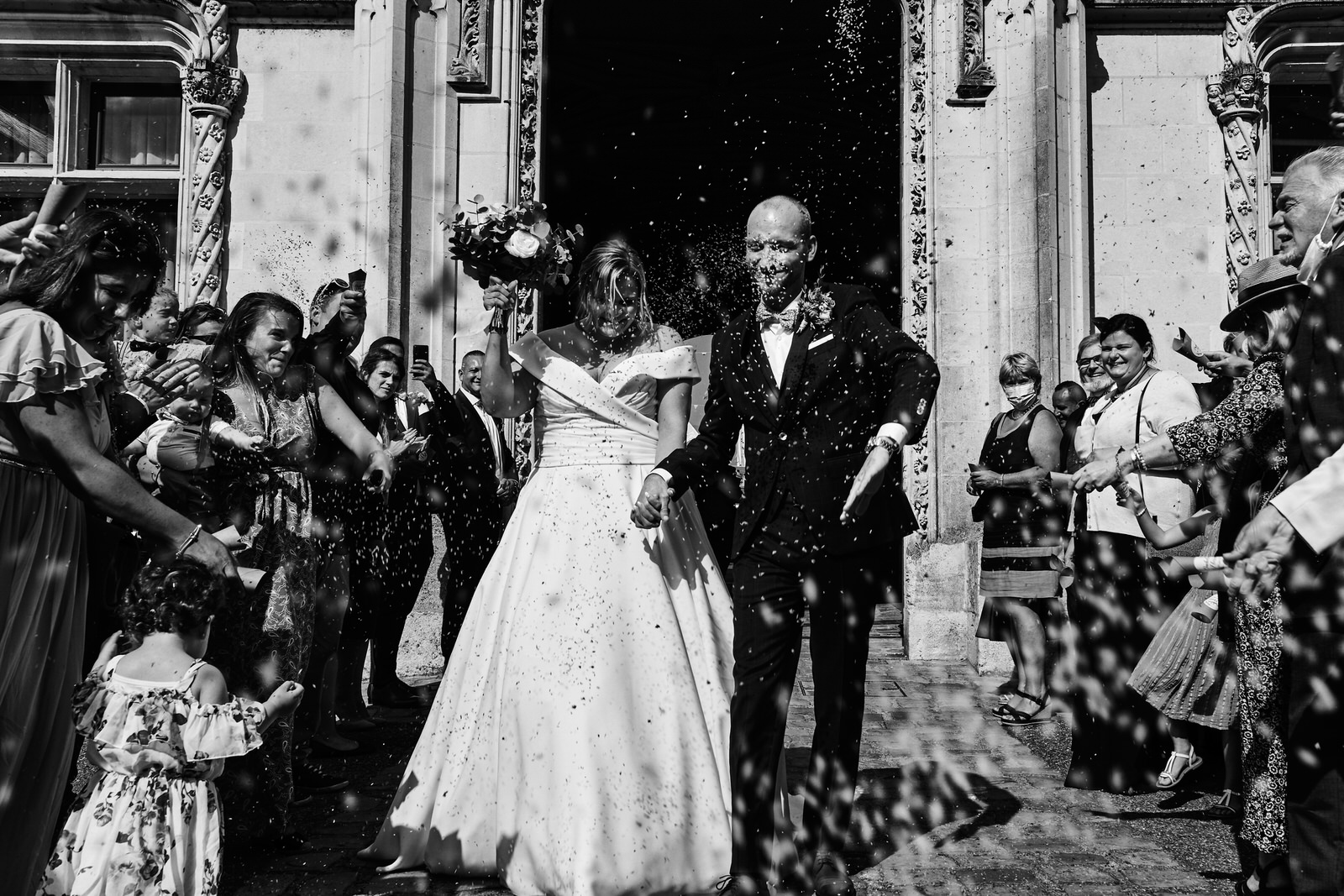 sortie de mairie, les invités lancent des pétales de fleurs sur les mariés