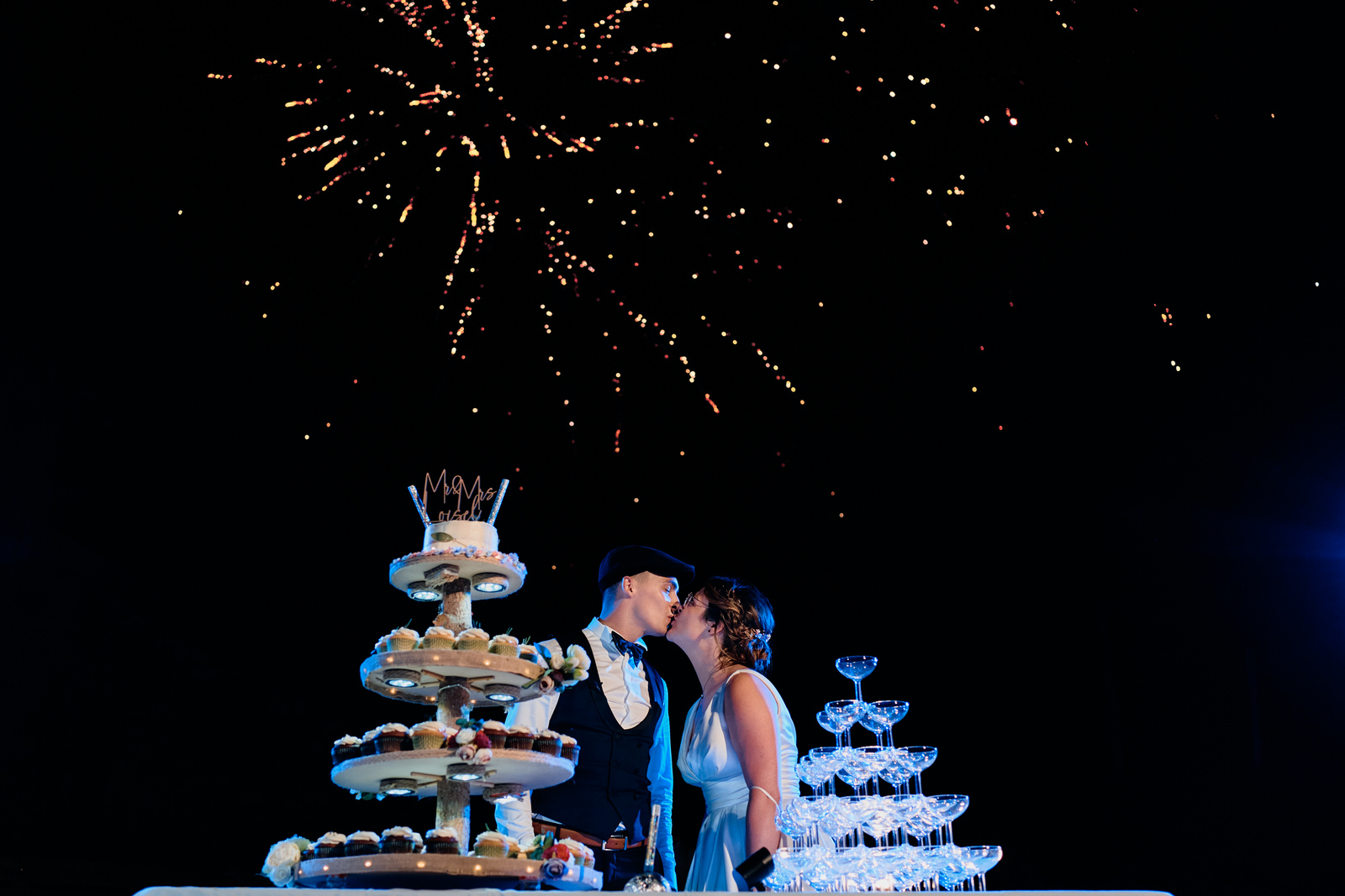 mariés qui s'embrassent devant un feu d'artifice