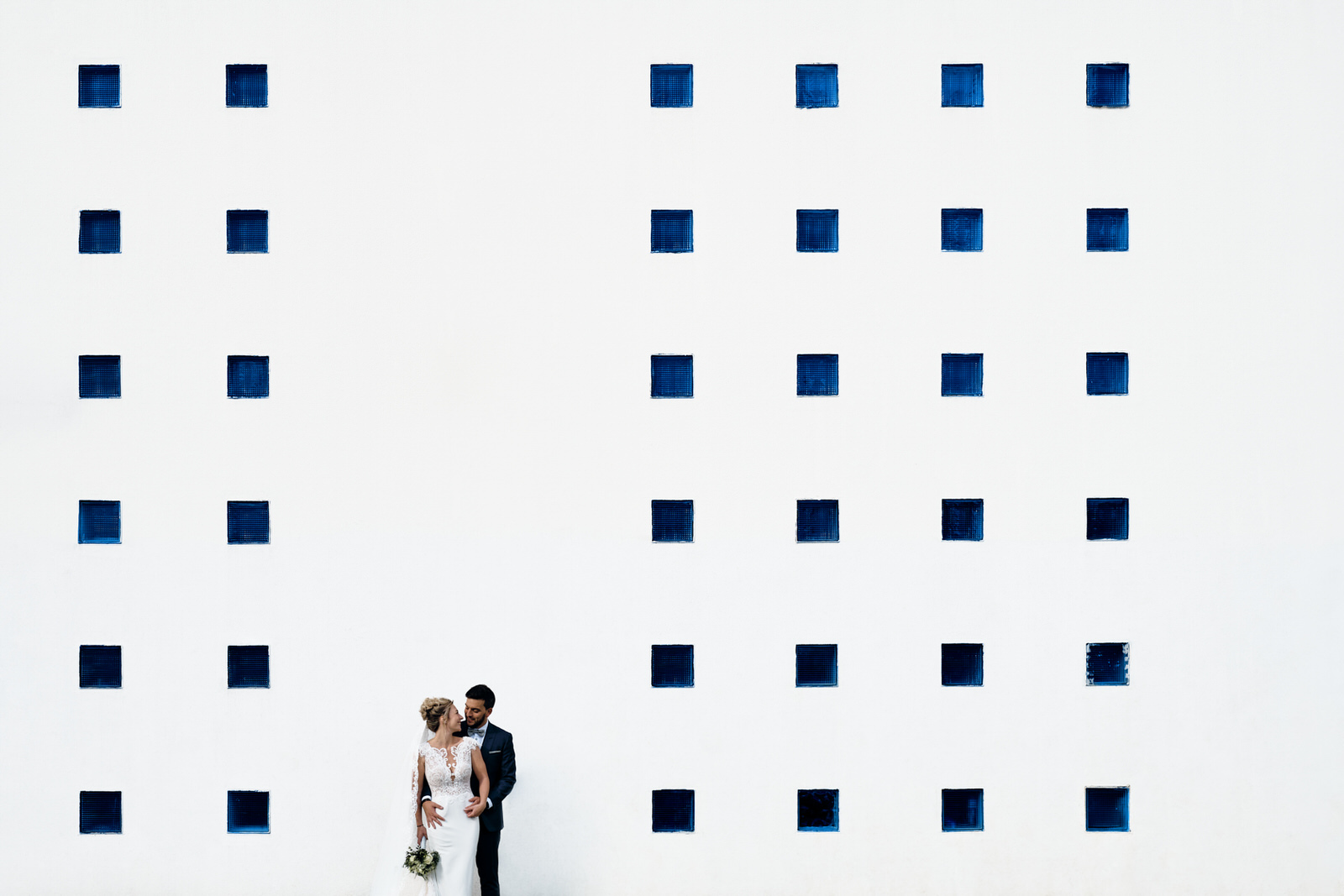 photo de couple devant une facade de batiment très graphique