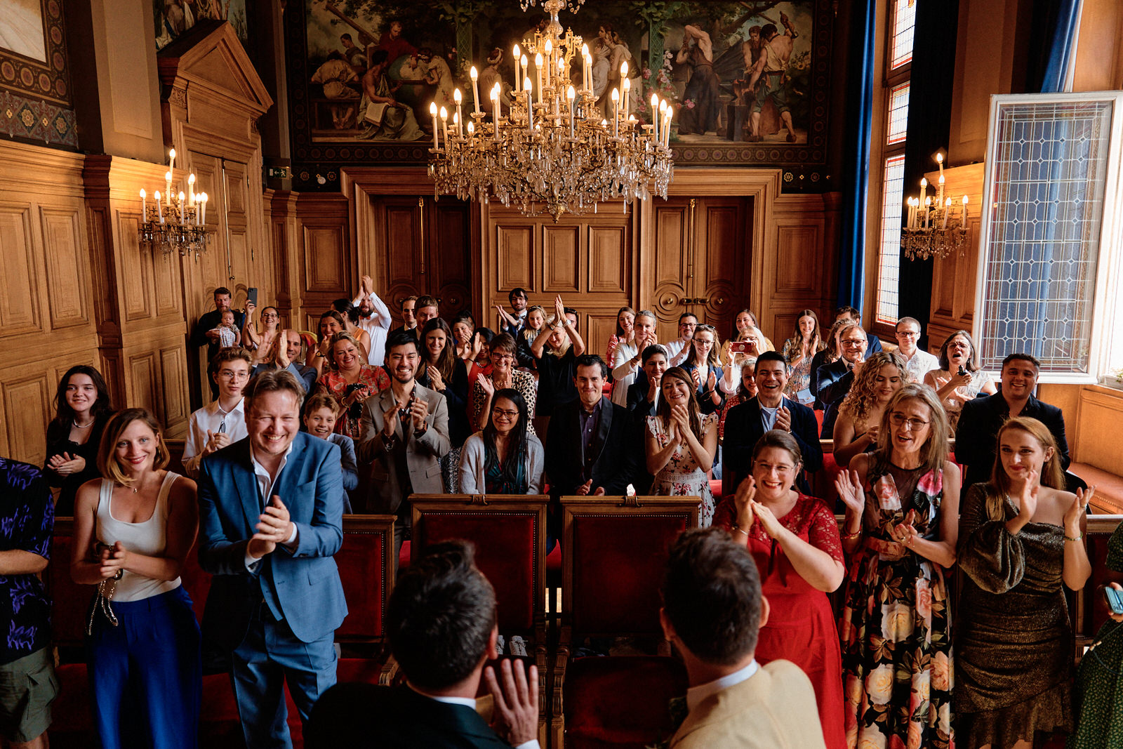 Invités de mariage applaudissant pour féliciter les mariés lors de la cérémonie civile à la mairie du 13ème dans Paris