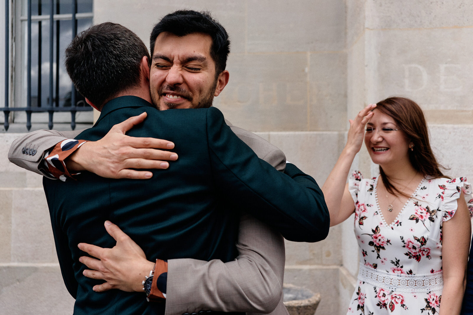 Invité faisant un câlin au marié avant la cérémonie civile à la mairie du 13ème de Paris
