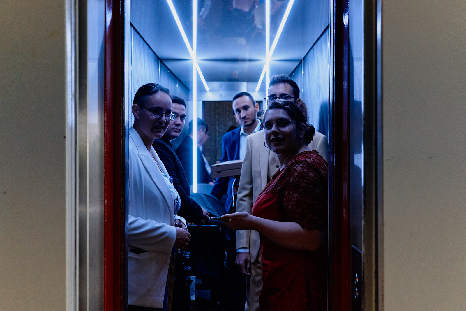 Marié et invités de mariage dans un ascenseur