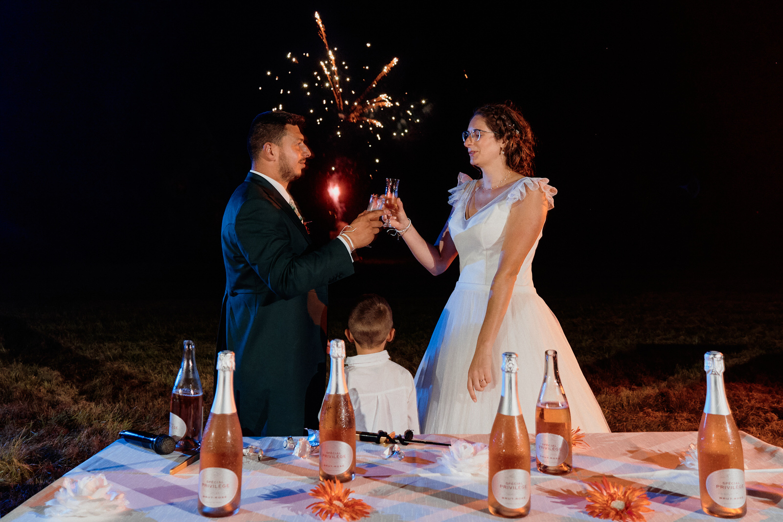 le père de la mariée sert dans ses bras la mariée et la main de la mère de la mariée s'agrippe au bras du père