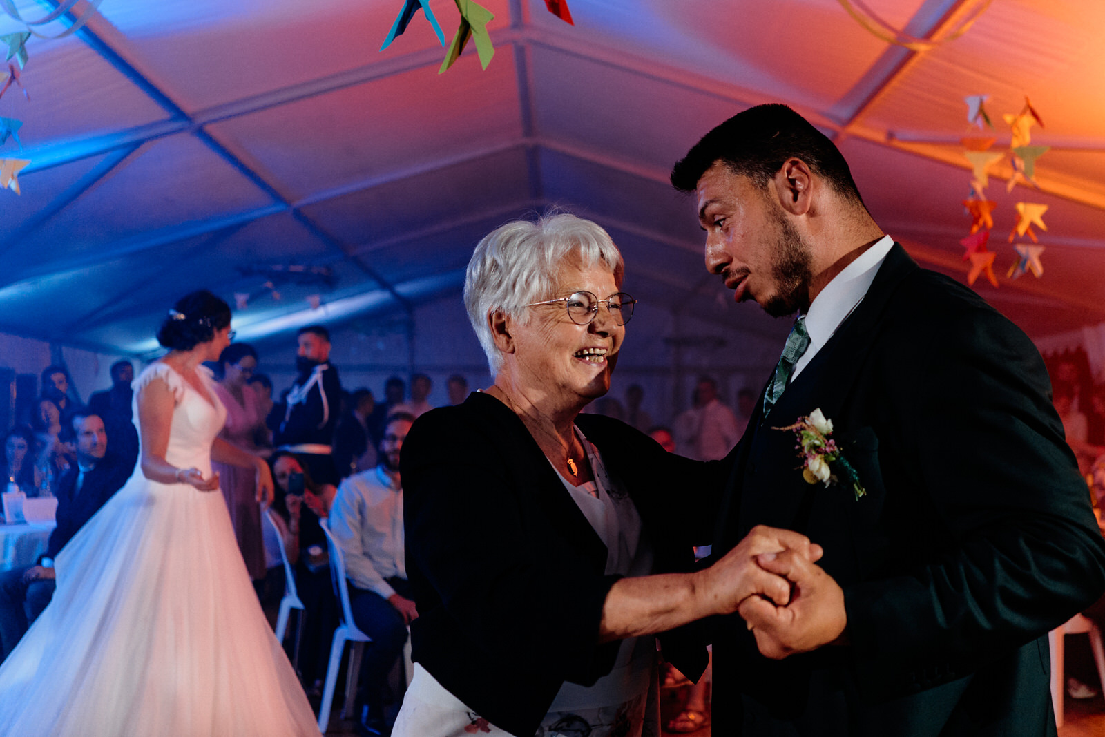 le père de la mariée sert dans ses bras la mariée et la main de la mère de la mariée s'agrippe au bras du père