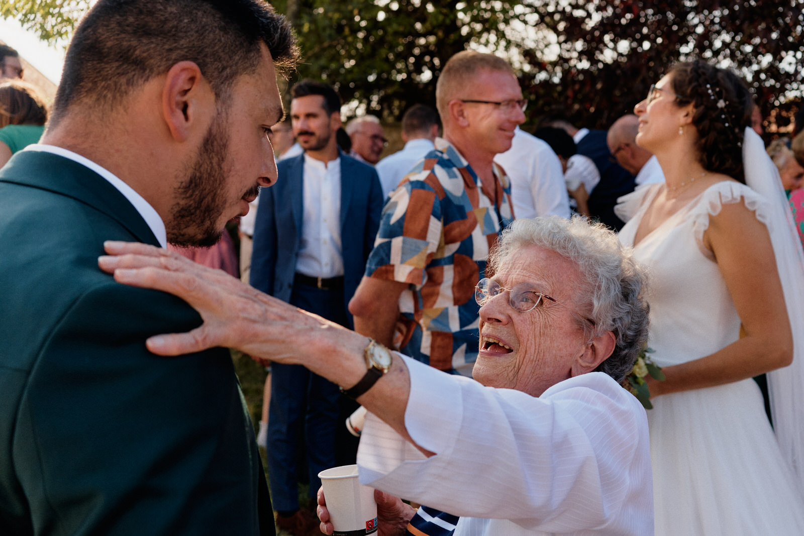 le père de la mariée sert dans ses bras la mariée et la main de la mère de la mariée s'agrippe au bras du père