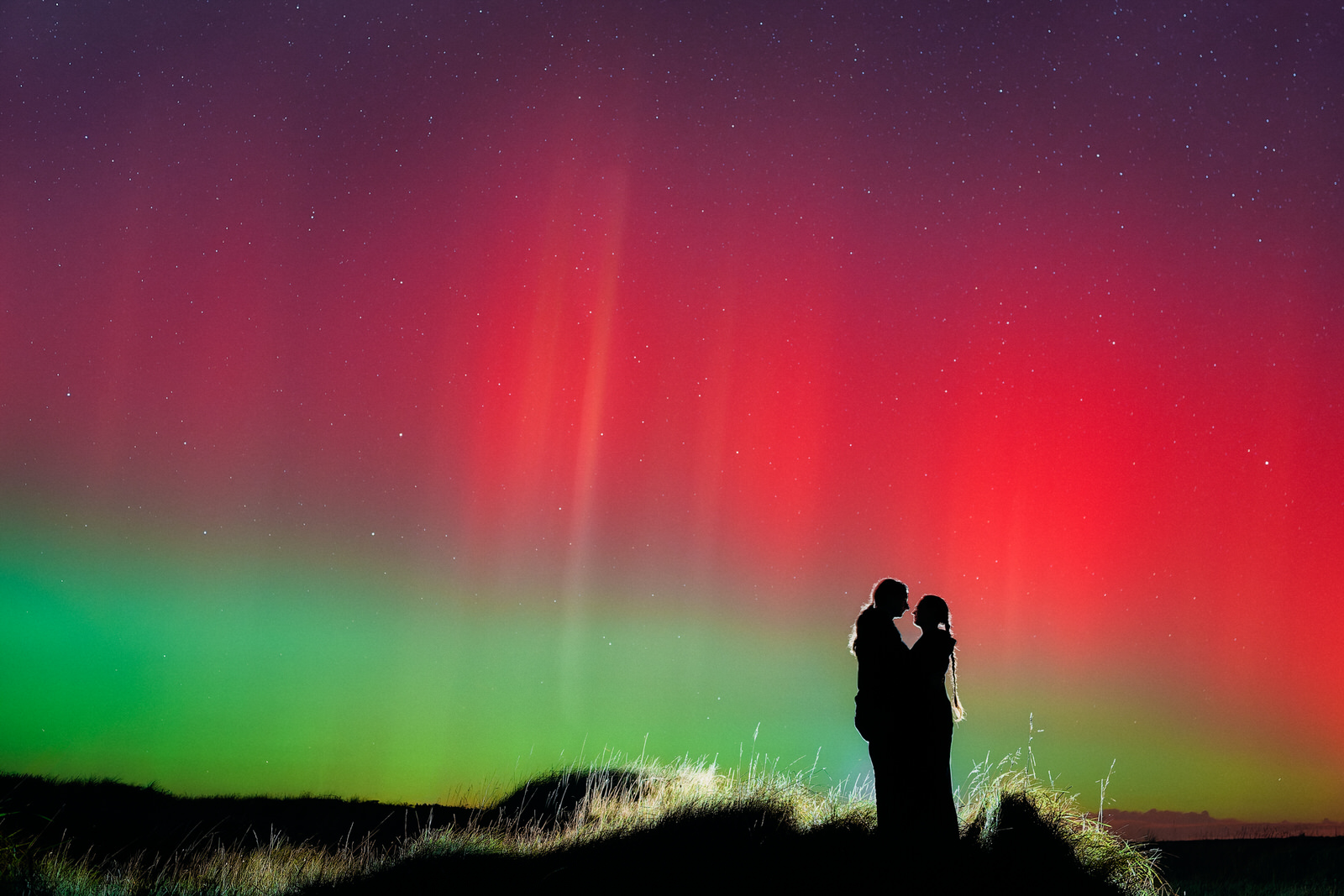 Photo de couple en silhouette sous les aurores boréales