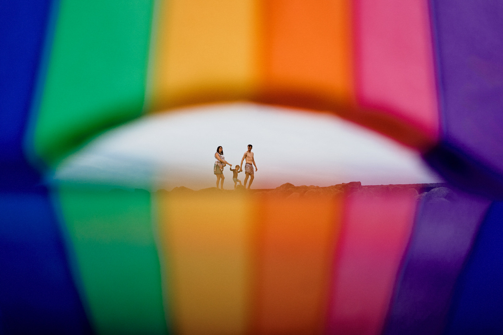 Photo graphique et créative d'une famille avec une bouée de plage arc en ciel