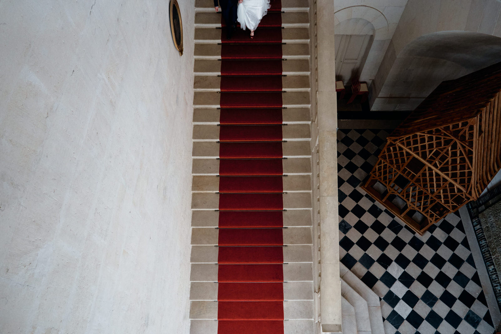 Point de vue créatif de la sortie de mairie d'un couple de mariés, on devine seulement leurs pieds descendre les escaliers, la photo et prise en plongée