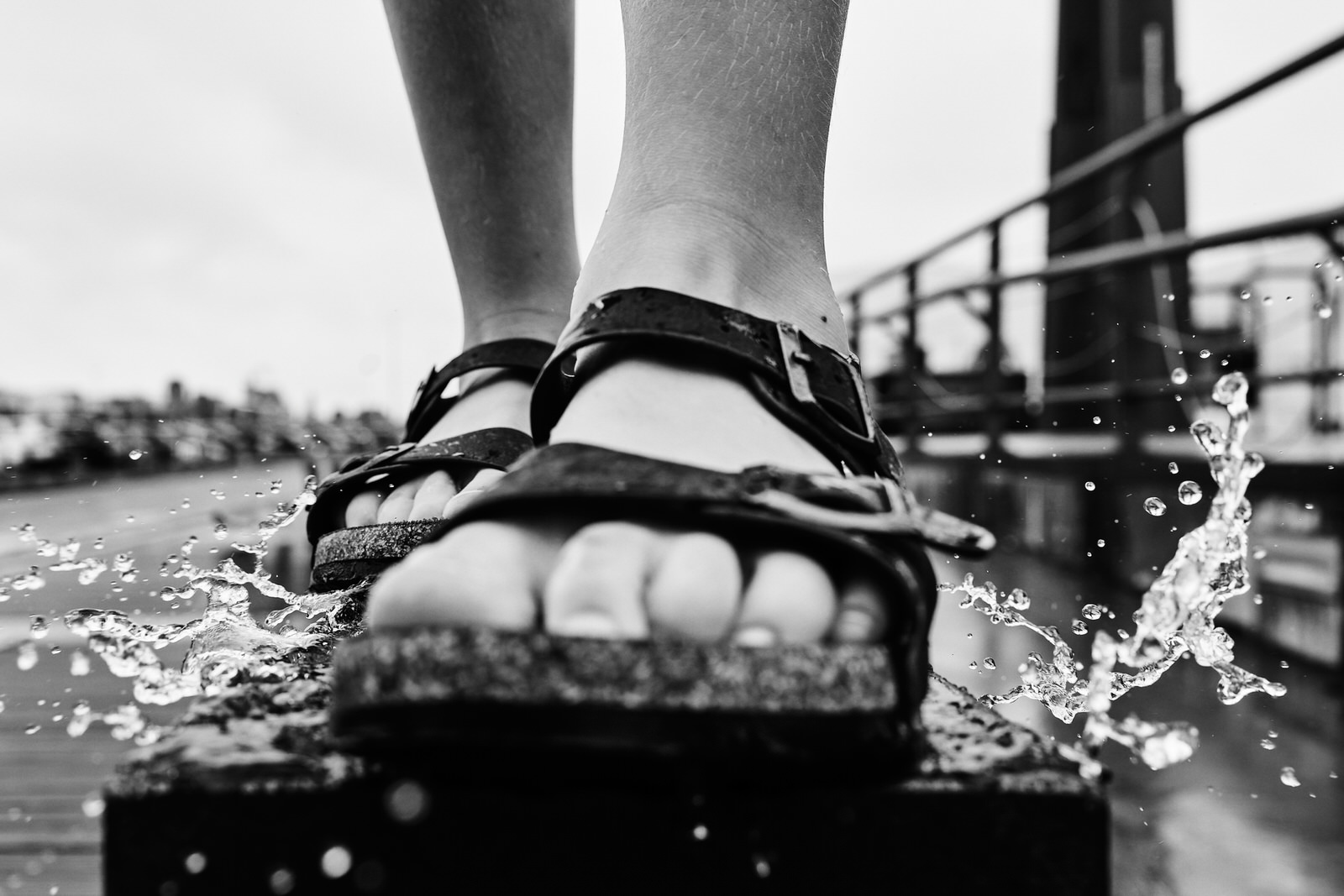 Pied d'un enfant marchant dans une flaque pendant une séance lifestyle sous la pluie