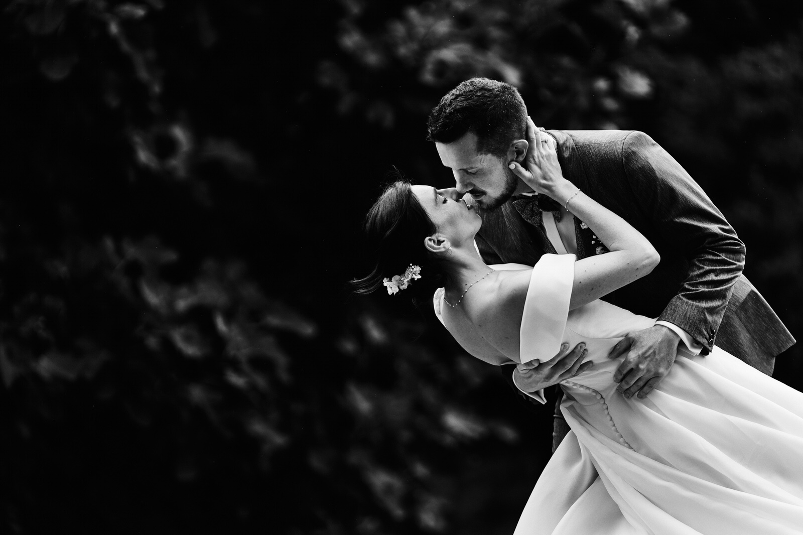 photo de couple de mariés, le marié embrasse la mariée en la penchant en arrière