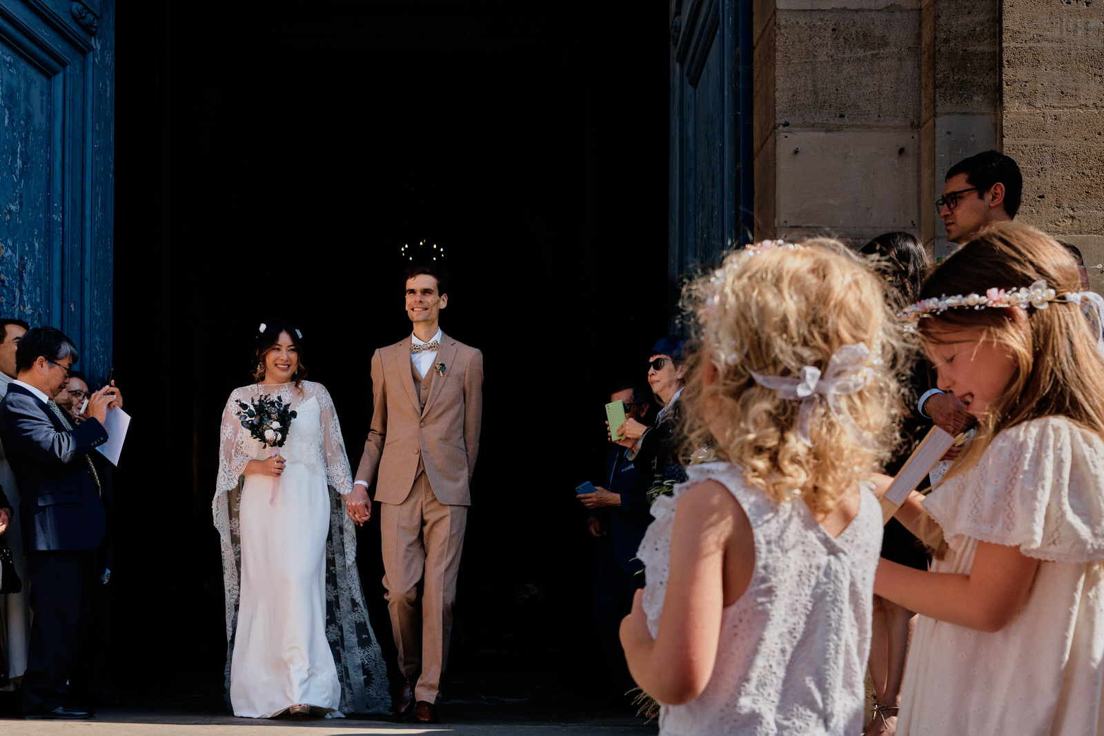 sortie d'église lors d'un mariage, les mariés sortent de l'église, le marié à une auréole au dessus de la tête à cause d'un lustre