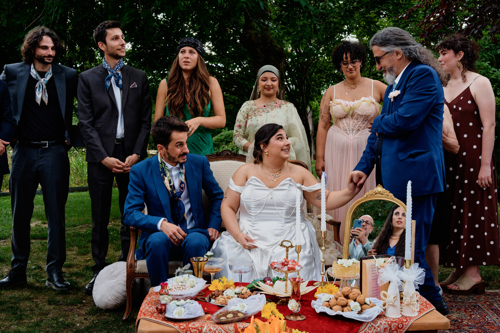 cérémonie iranienne de mariage, tous les invités sont derrières les mariés, la mariée regarde et tient la main de son père