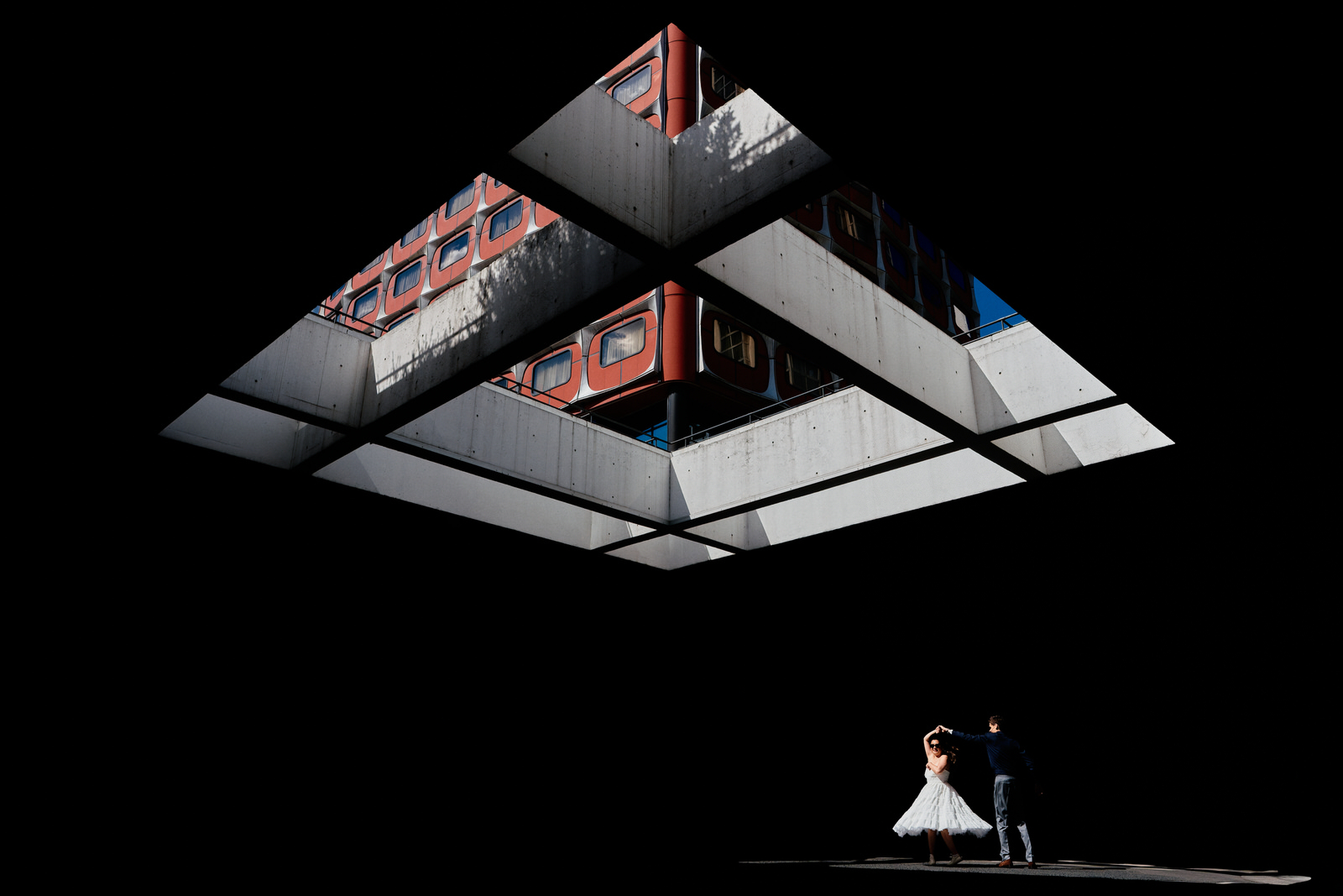 photo de couple de marié qui danse dans un puit de lumière en forme de triangle